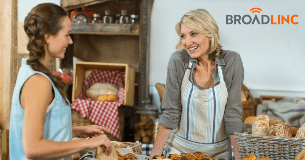 Business owner talking to customer in bakery