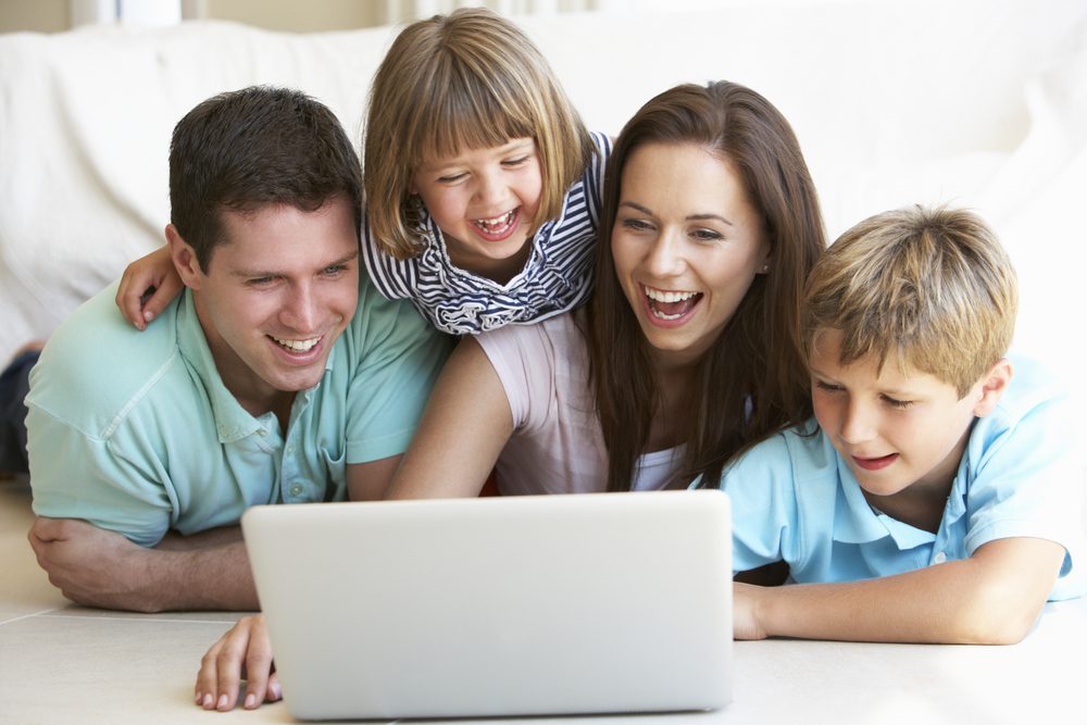 Young parents, with children, on laptop computer